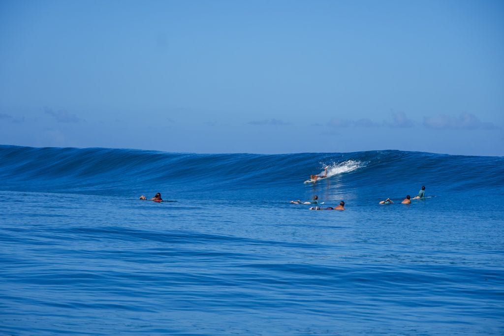 A picture of Kristin and several others surfing at Teahupoo in Tahiti
