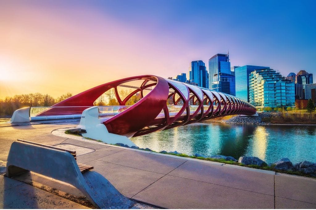 A picture of Peace Bridge, which crosses over Bow River. Calgary's downtown skyline is in the background.