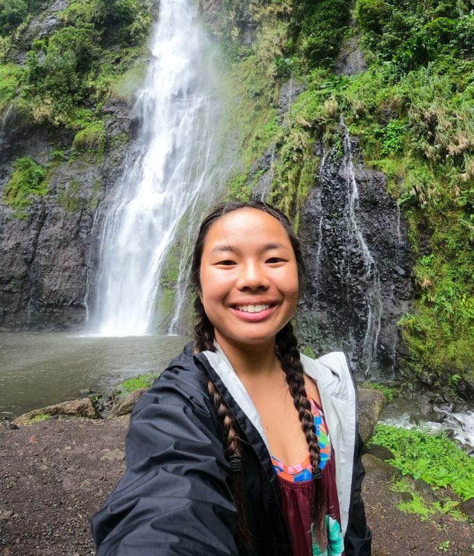 A picture of Kristin at one of the island's many waterfalls. Pack a light jacket for your vacation in Tahiti if you plan on hiking because it can prevent bug bites and the temperature drops around the waterfalls.