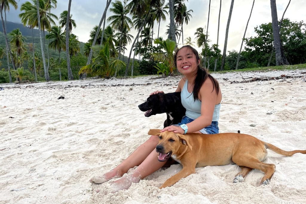 A picture of Kristin and two furry friends she met on one of the local beaches.