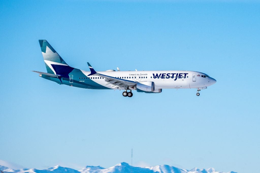 A picture of a Westjet airplane about to land at the YYC airport.