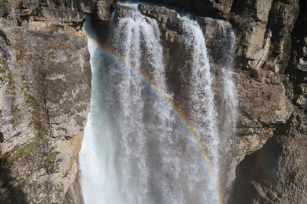 A picture of Upper Falls with a rainbow streaking across in Johnston Canyon. 