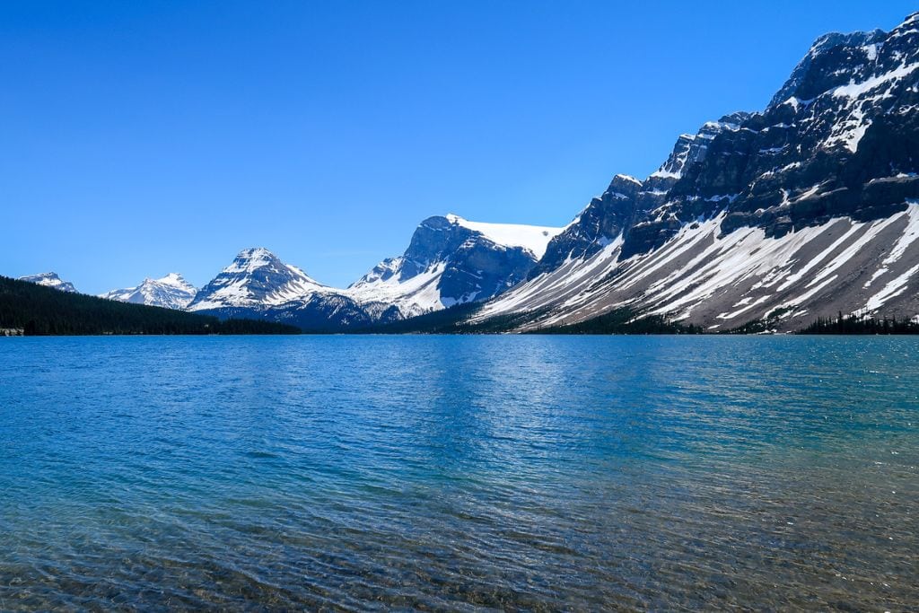 A picture of the 10th stop, Bow Lake, in the travel guide to Banff. Bow lake is surrounded by several snow capped mountains and is one of the less frequented lakes.