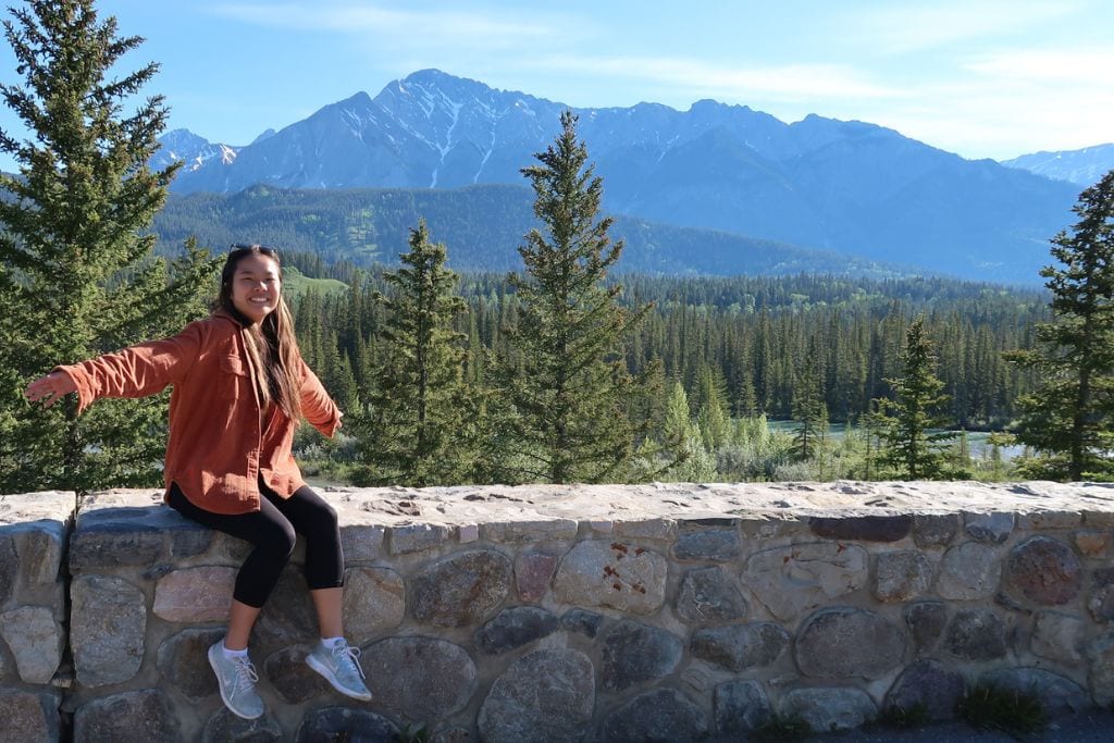 A picture of Kristin with the mountains and Banff's forest trees in the background.