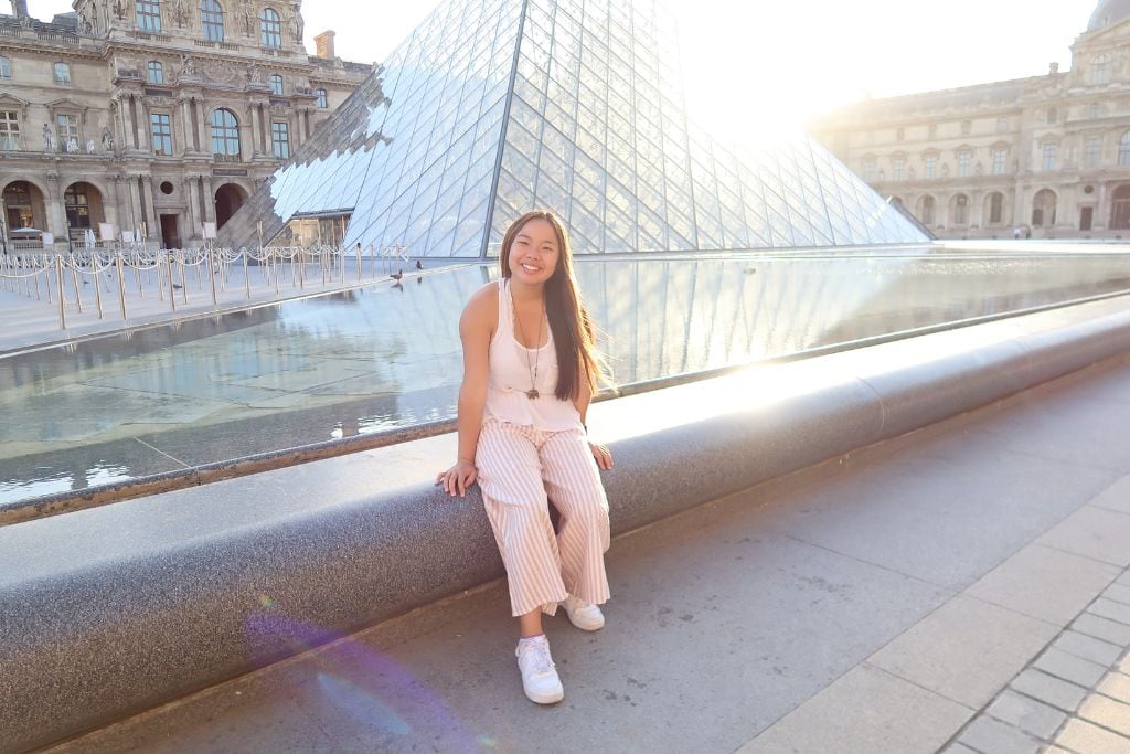 Picture of Kristin smiling outside of the Louvre. 