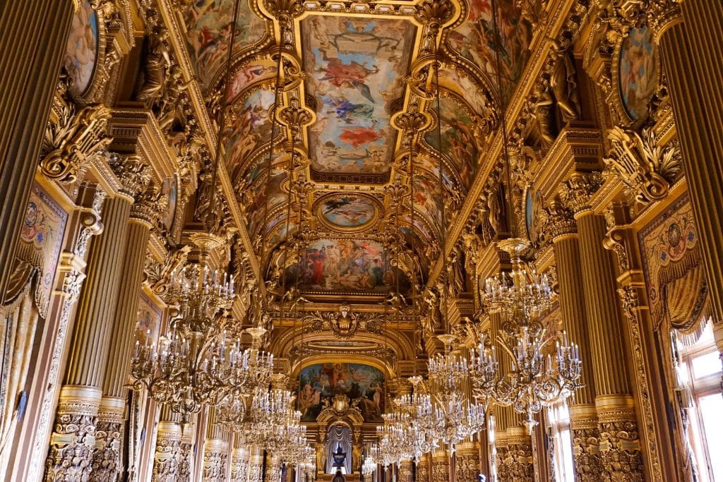 The grandiose ceiling and intricate frescos that can be seen in the foyer of the Opéra Garnier. Attending a performance here and seeing the elaborate detailing is sure to make your trip to Paris worth it.