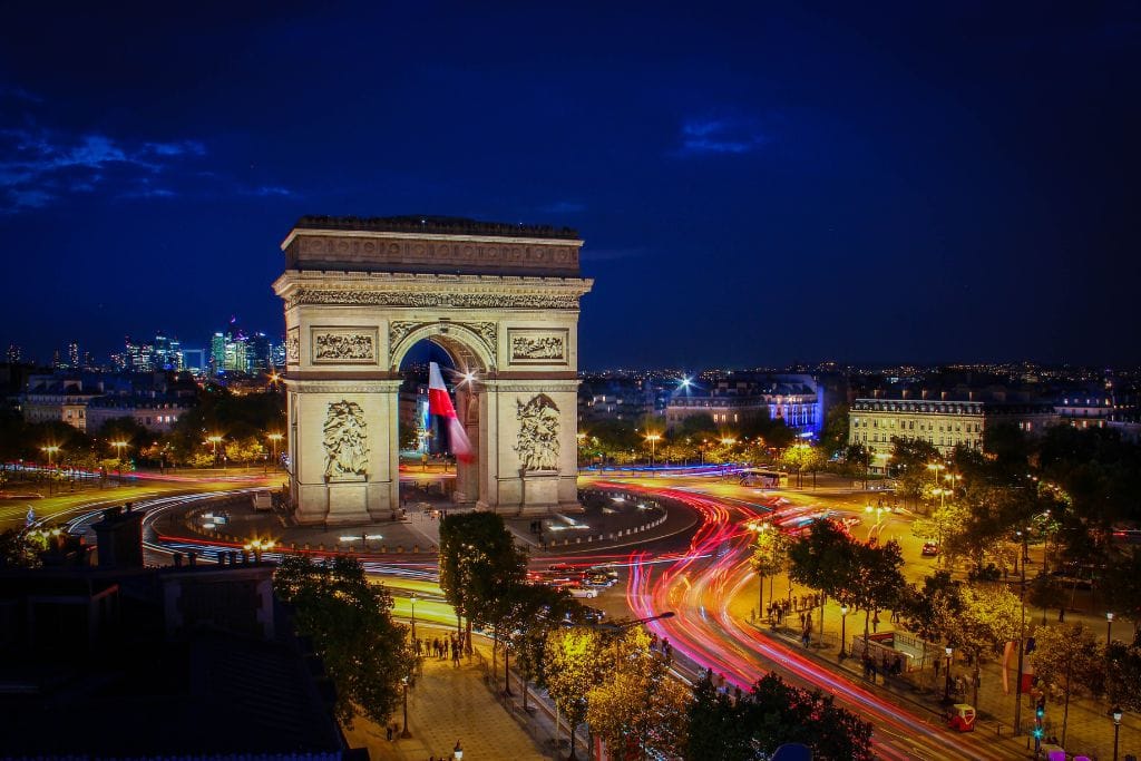 A long-exposure shot of the Arc de Triomphe at night. 