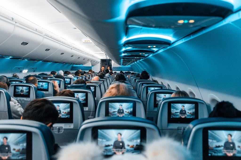 A picture of the interior of an airplane with all its passengers seated. 