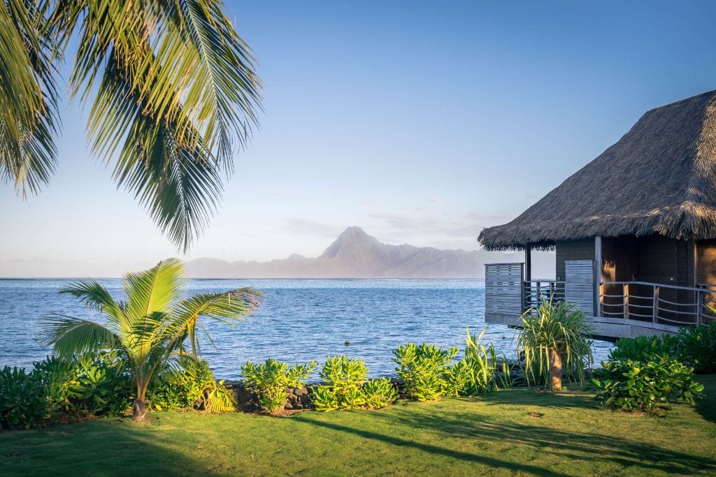 A picture an overwater bungalow that encapsulates the serene feeling of vacationing in Tahiti.