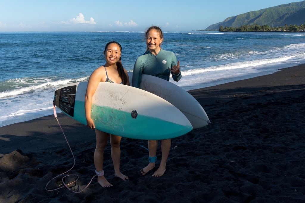 A picture of Kristin and her friend with their surfboards at Plage Taharuu.