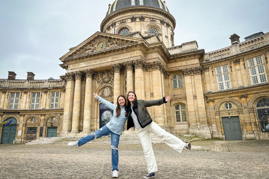 A picture of Kristin and her friend posing in front of the Institut de France