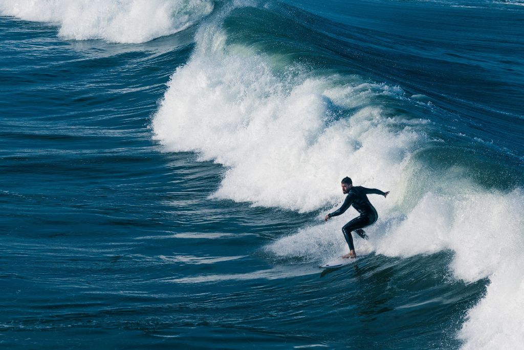 A picture of a man surfing in a larger wave in San Diego.