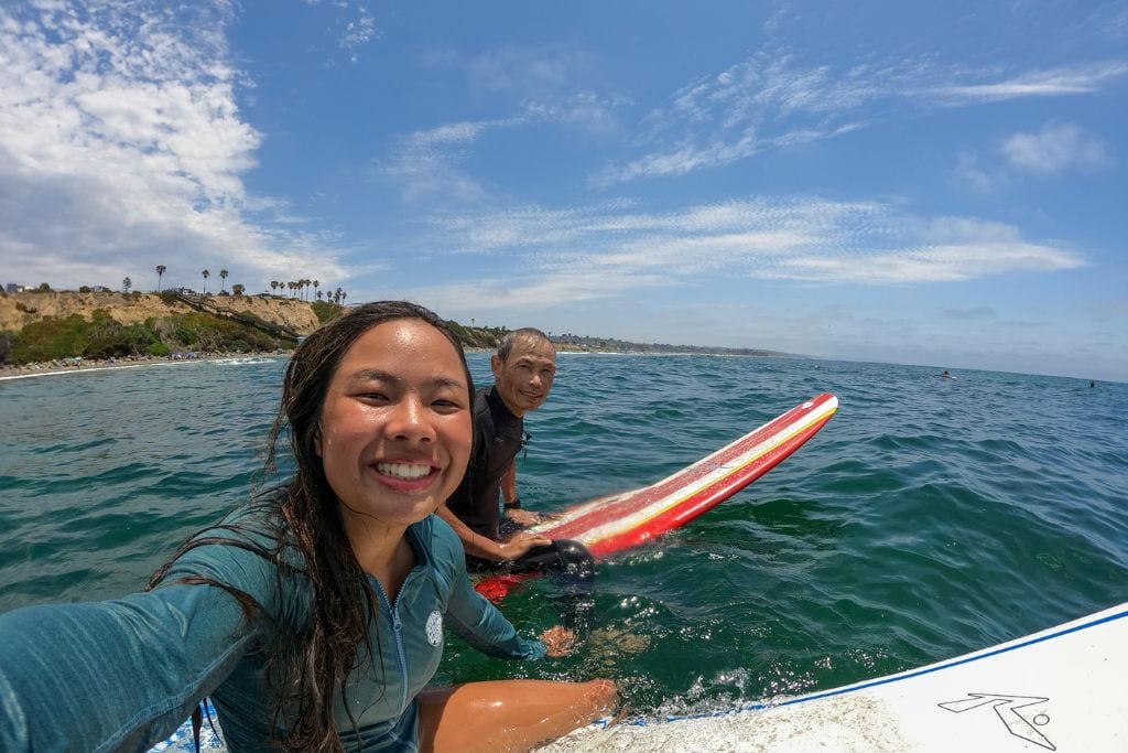 A selfie of Kristin and her dad surfing at San Elijo State Beach in the northern part of San Diego.