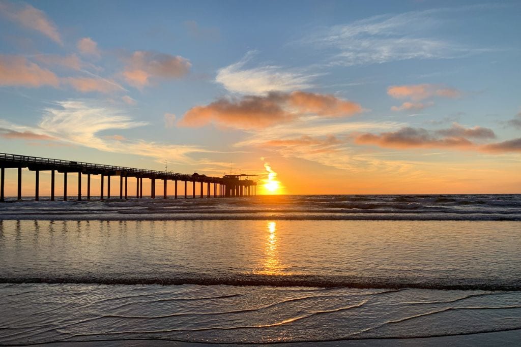 A picture of sunset with the Scripps pier in the picture. Scripps is one best beginner surf spots in San Diego.
