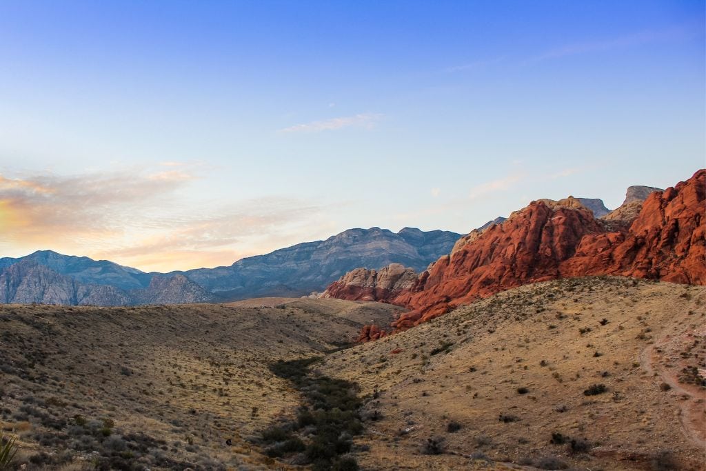 A picture of the rolling hills that can be found in Red Rock Canyon. In the background, you see some of infamous Red Rock formations.
