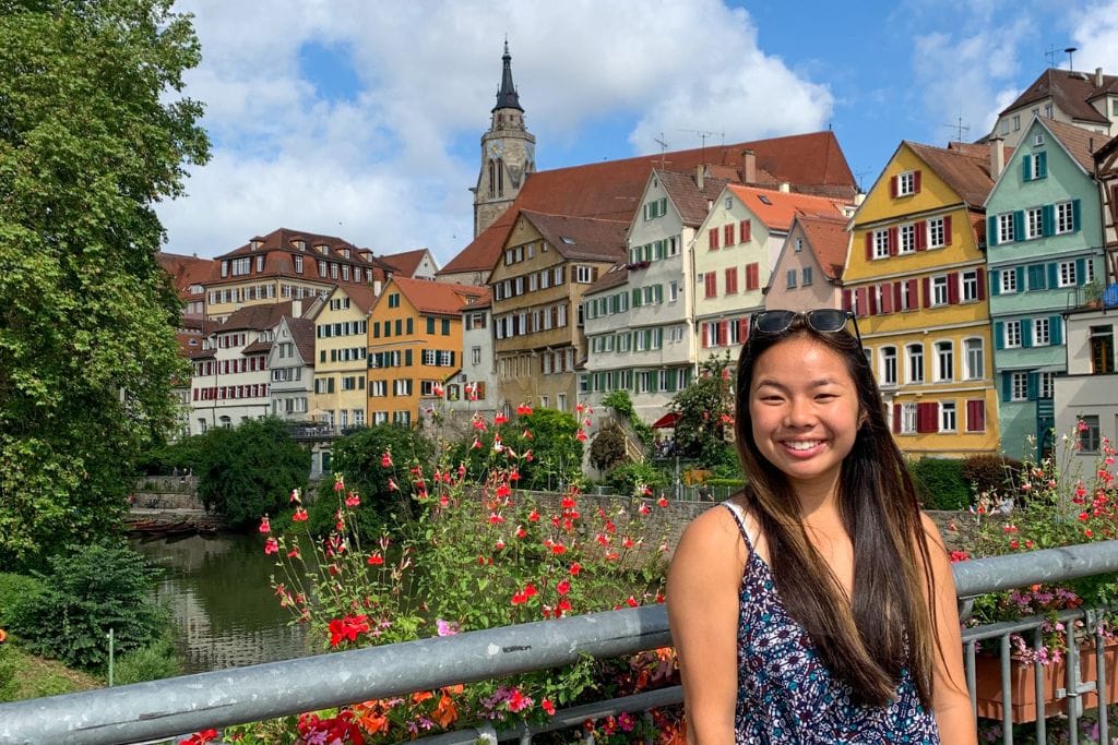 A picture of Kristin smiling while standing on the main bridge that crosses over the Neckar River in Tubingen.