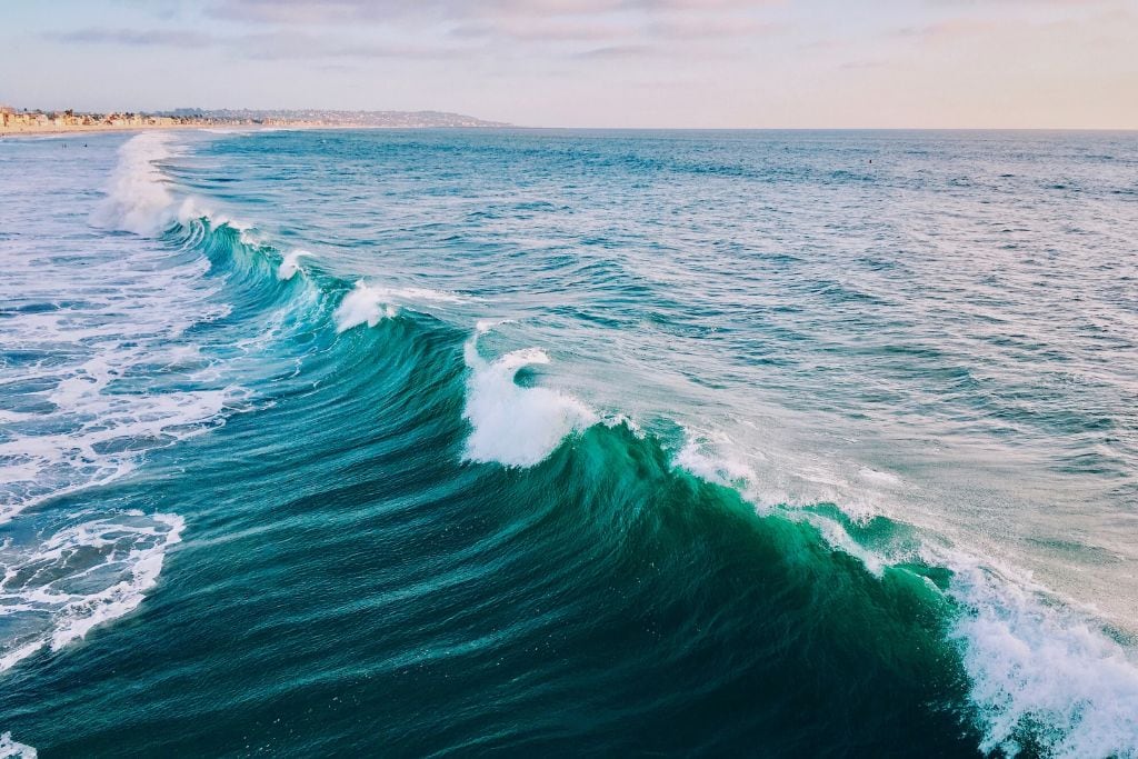 picture of beautiful blue green waves taken from a pier