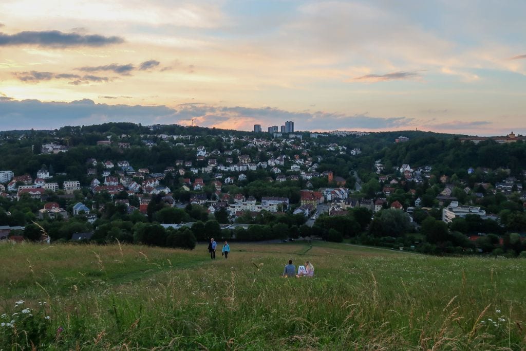 A picture of the sunset and all the white city buildings sprinkled in the distance on the hill opposite of me.