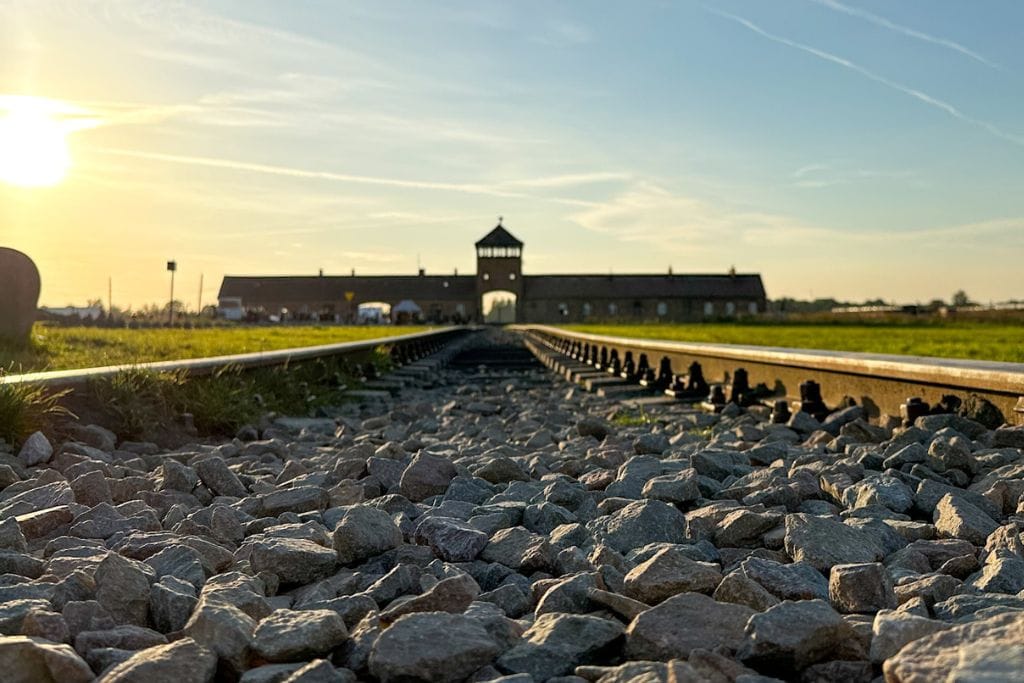 A picture taken low to the ground of the train tracks that lead into Auschwitz II Birkenau camp. This is one of the iconic sights you'll see on your day trip from Krakow to Auschwitz. 