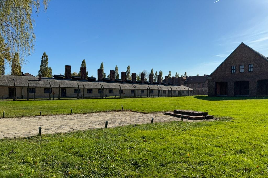 A picture of the big grassy field that is in Auschwitz I camp, before you pass through the infamous gate. You will see this on your day trip to Auschwitz from Krakow during the tour. 