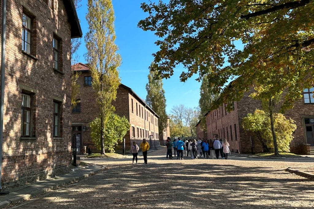 A picture of people tour Auschwitz I camp. During your day trip to Auschwitz from Krakow, you'll go on a tour with a guide educator. 