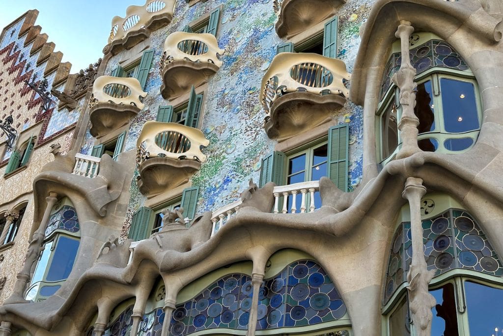 A zoomed in picture of the balconies on Casa Batlló. You can see the iron work that is built into the white structures that mimic skulls or venetian masks. Again, seeing how Casa Batlló embodies the Legend of Saint George and the Dragon is one of the reasons why Casa Batlló is worth visiting, at least from the outside.