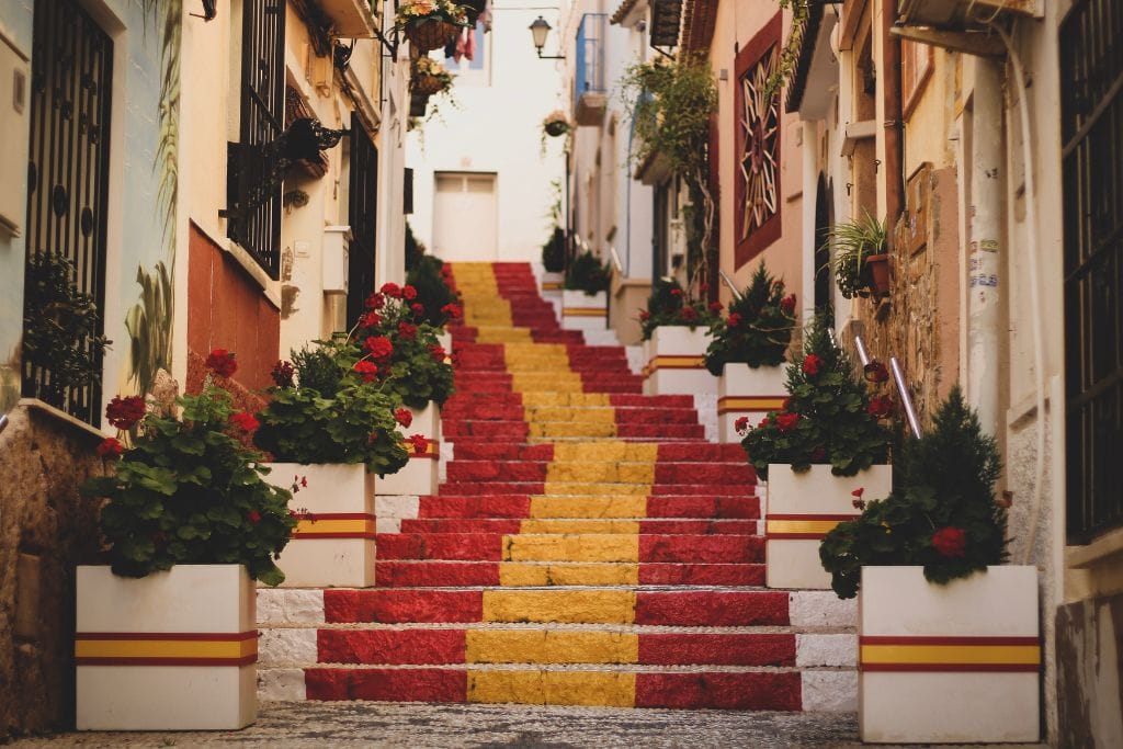 A picture of steps that are red and yellow. They can be found in Calp, Spain.
