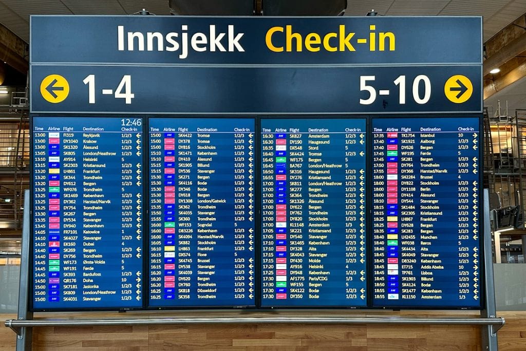 A picture of a flight departure board. A good tip for first time flyers is to constantly check the flight departure board for any flight changes.
