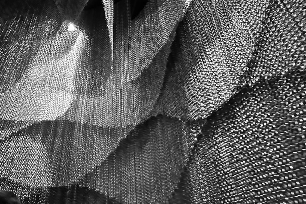A picture of part of Kengo Kuma's art piece, "majestic stairs." There are tons of chainmail cut at various lengths to mimic the pattern of dragon scales. 