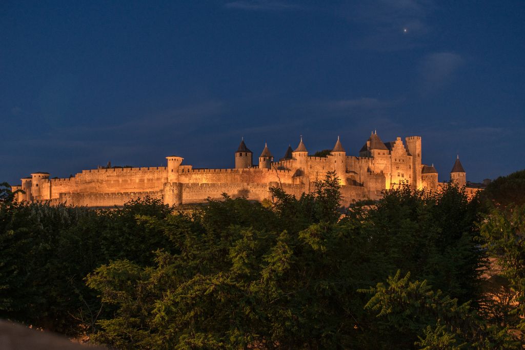A picture of Carcassonne lit up by flood lights at night.