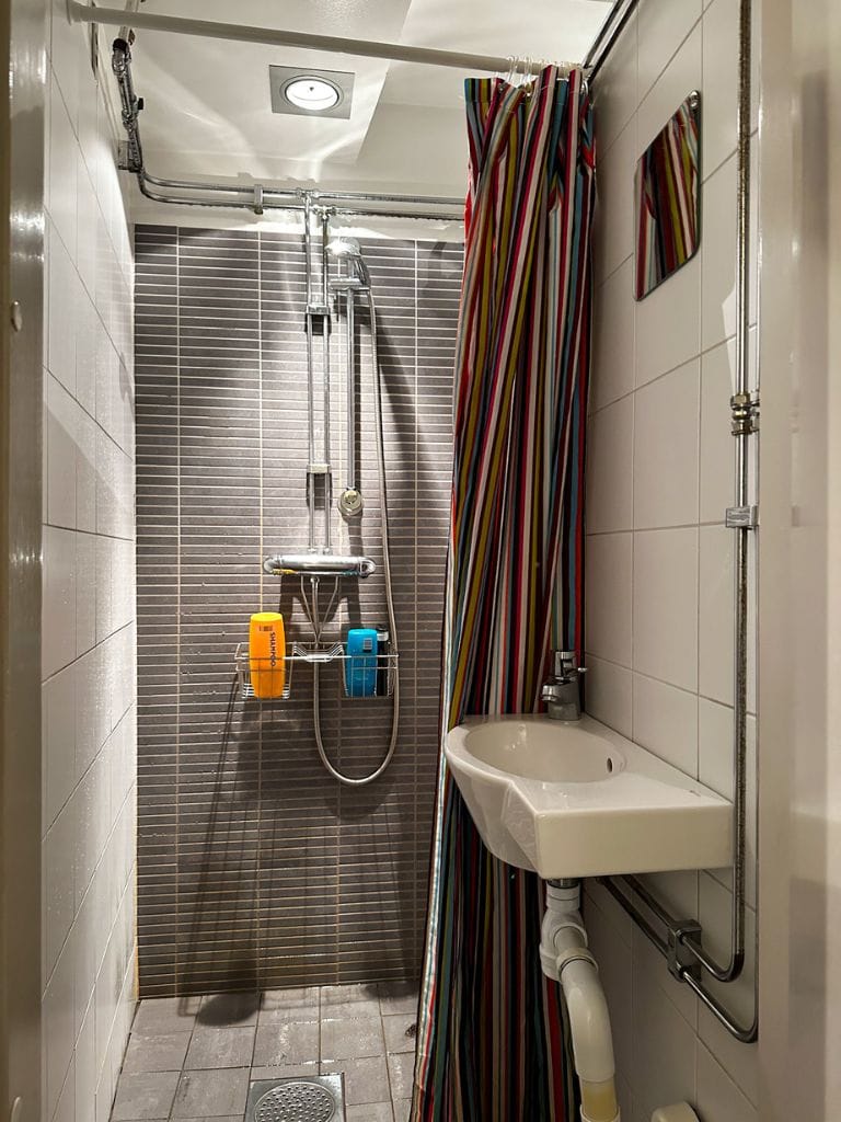 A picture of one of the shower stalls at Castanea Old Town Hostel Stockholm. You can see that shampoos and conditioners are provided for free for those who forget to bring their own.