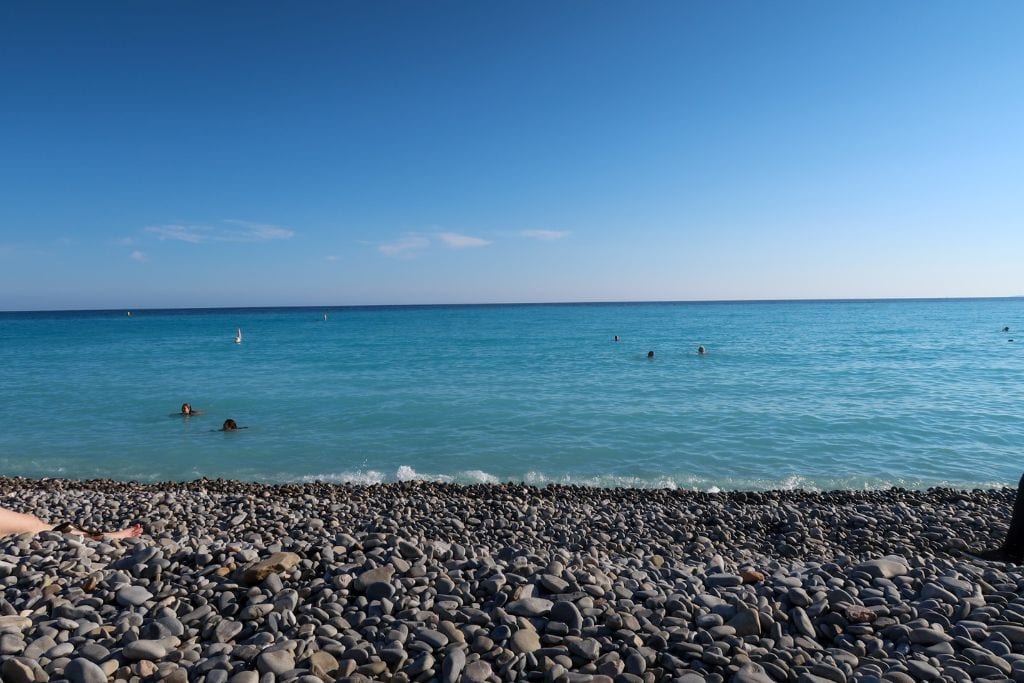 A picture of the gorgeous Ponchettes Beach which includes the unbelievably blue waters. if you have time, make sure to relax here for a few moments during your one day in Nice France.