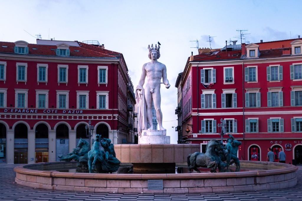 A picture of Place Massena. Stop here during your one day in Nice France if you want to see the iconic red buildings and distinct black and white tiles.