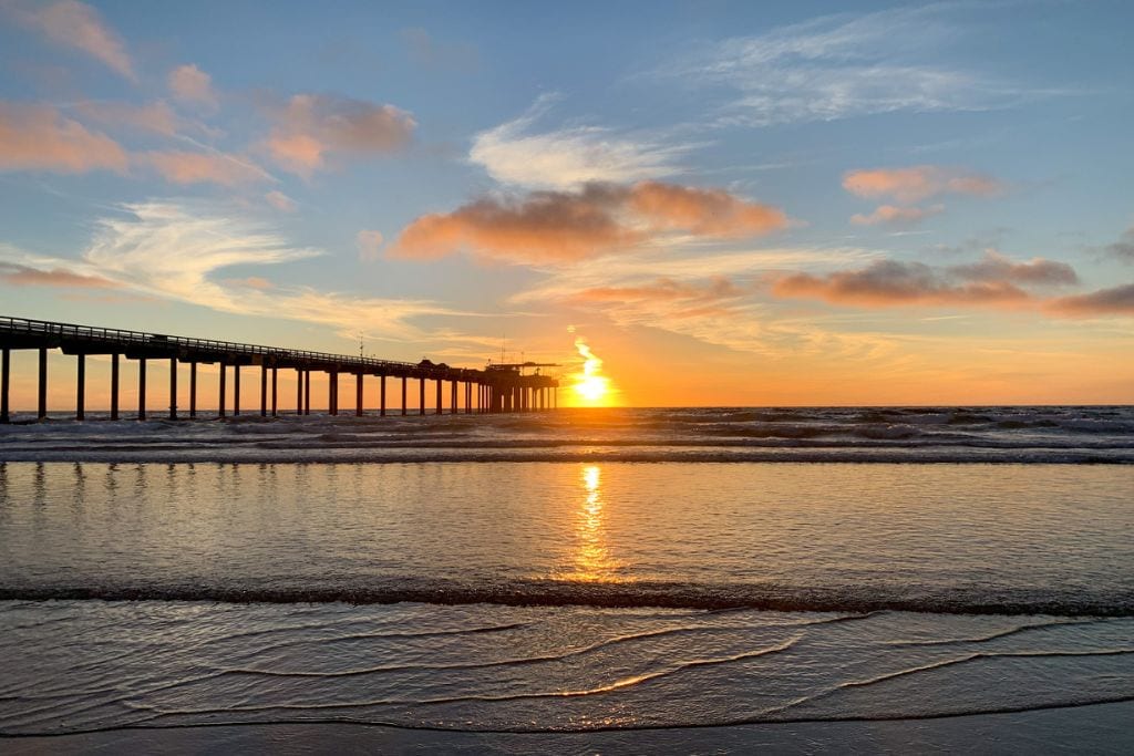 A picture of a sunset over the Scripps Pier. La Jolla is a pretty walkable neighborhood in San Diego.
