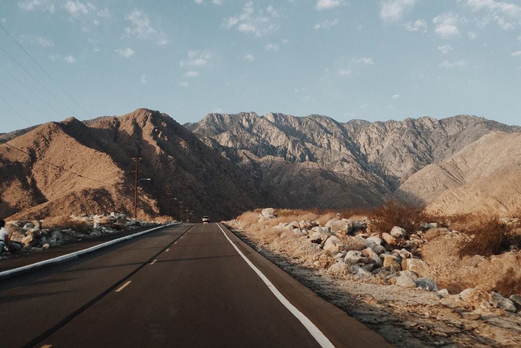 A picture of a road heading towards the mountains in Palm Springs. You'll take the scenic route if you do this palm springs tour that goes to the San Andreas Fault.
