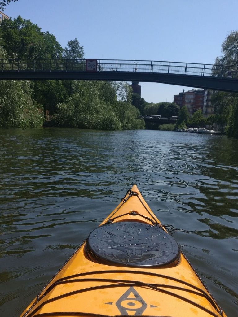 A picture of a yellow kayak while traversing the waterways of Stockholm.