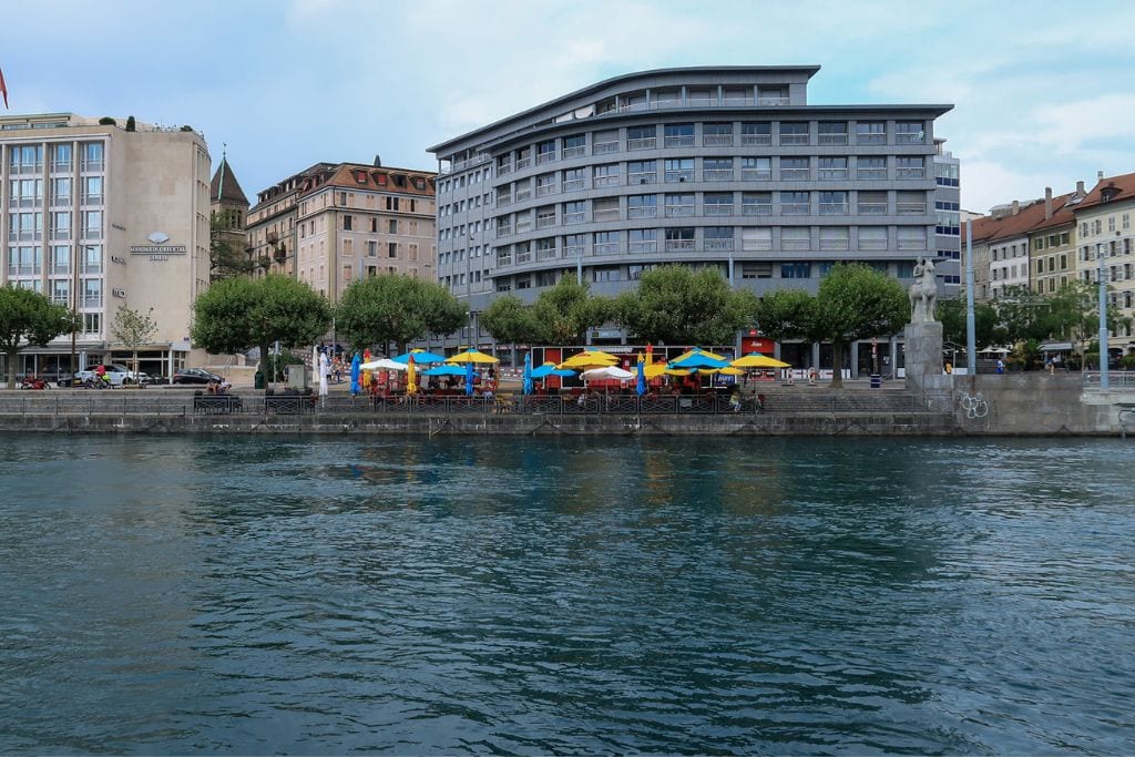 A picture of some buildings found in Geneva with the colorful umbrellas out front.
