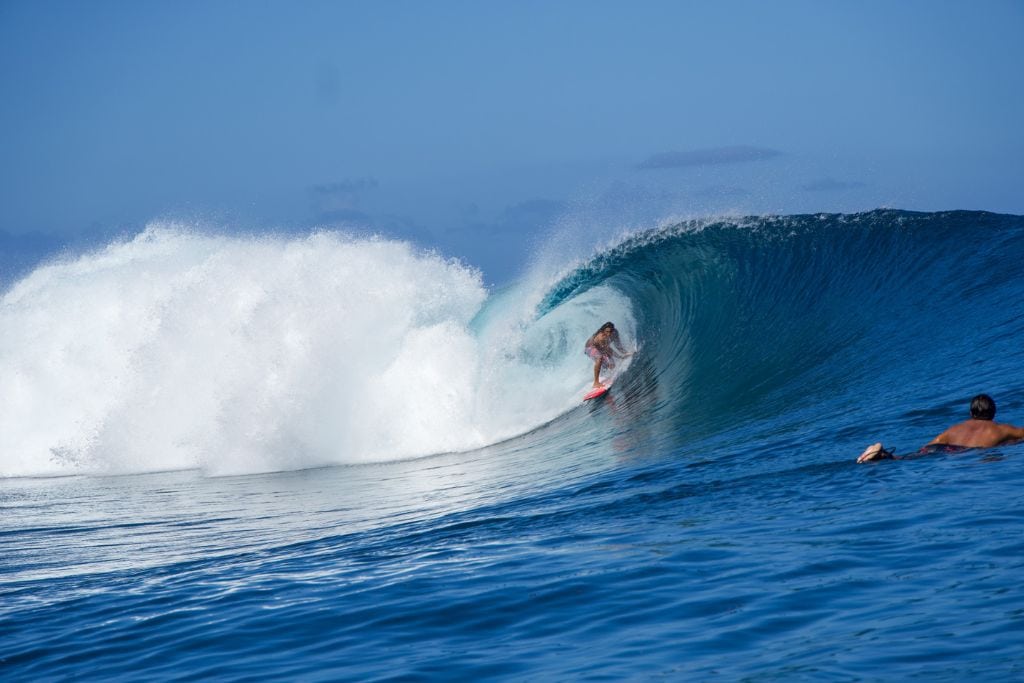 A picture of a local surfing the powerful Teahupoo.