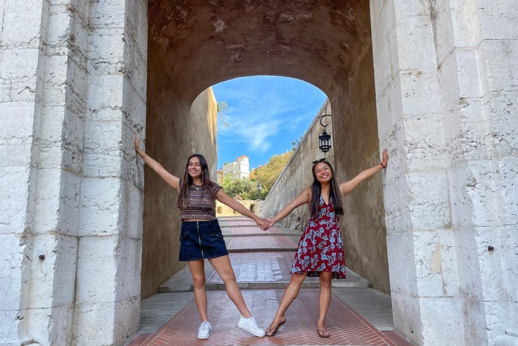A picture of Kristin and her friend posing underneath an arch on the Gateway to Rock.