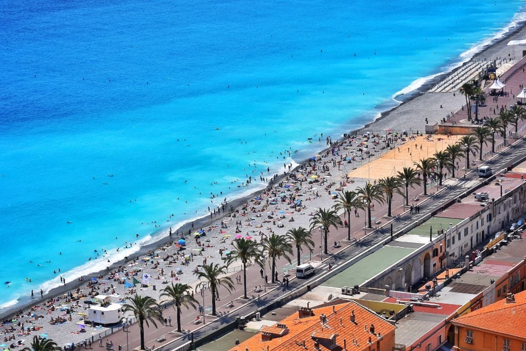 A picture of one of the beaches in Nice jammed packed with people. During the summer season, many people flock to both Nice and Monaco to take advantage of the beautiful beaches.