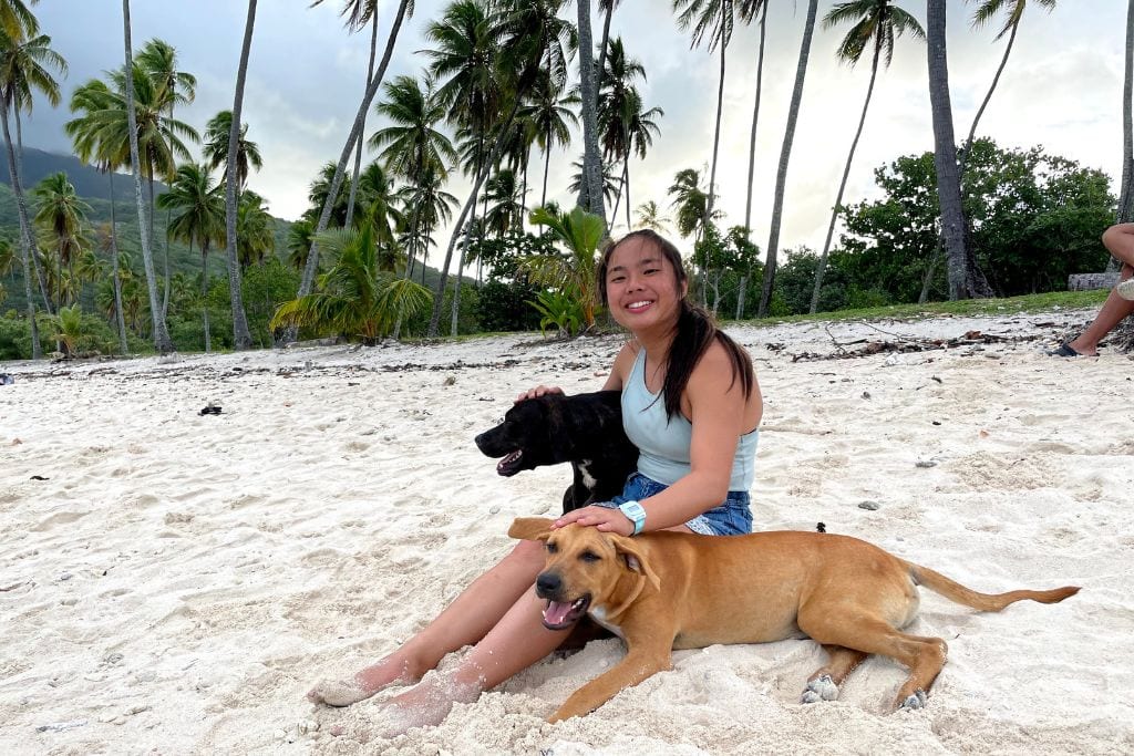 A picture of Kristin with some stray dogs on French Polynesia. I hope you have the best time on your next visit to Tahiti!