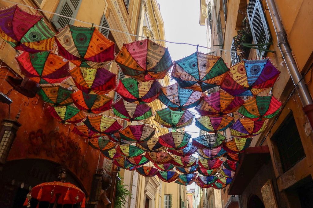 A picture of the colorful umbrellas hanging above in Nice's Old Town. Both Nice and Monaco have Old Towns with winding streets and colorful buildings.