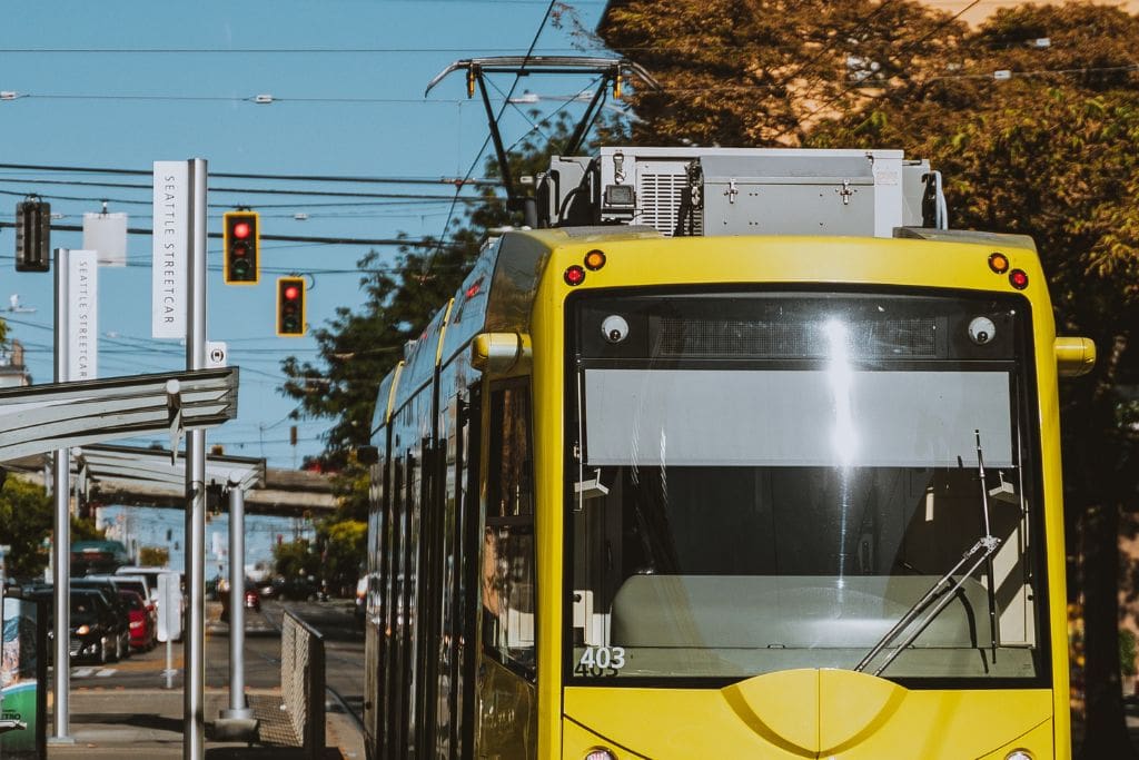 A picture of a yellow Streetcar in seattle. Seattle has excellent public transport that is not expensive.