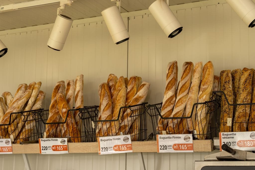 A picture of baskets of baguettes at a local boulangerie in Tahiti. Save money during your trip to French Polynesia by grabbing food from local markets!