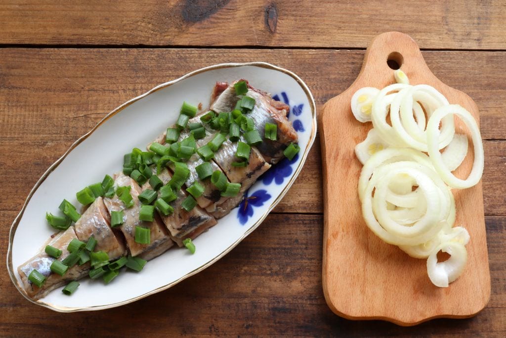 A picture of salted herring with onions on the side. Several of the food tours in Stockholm will allow you to taste some of the freshest seafood, including varieties of herring.
