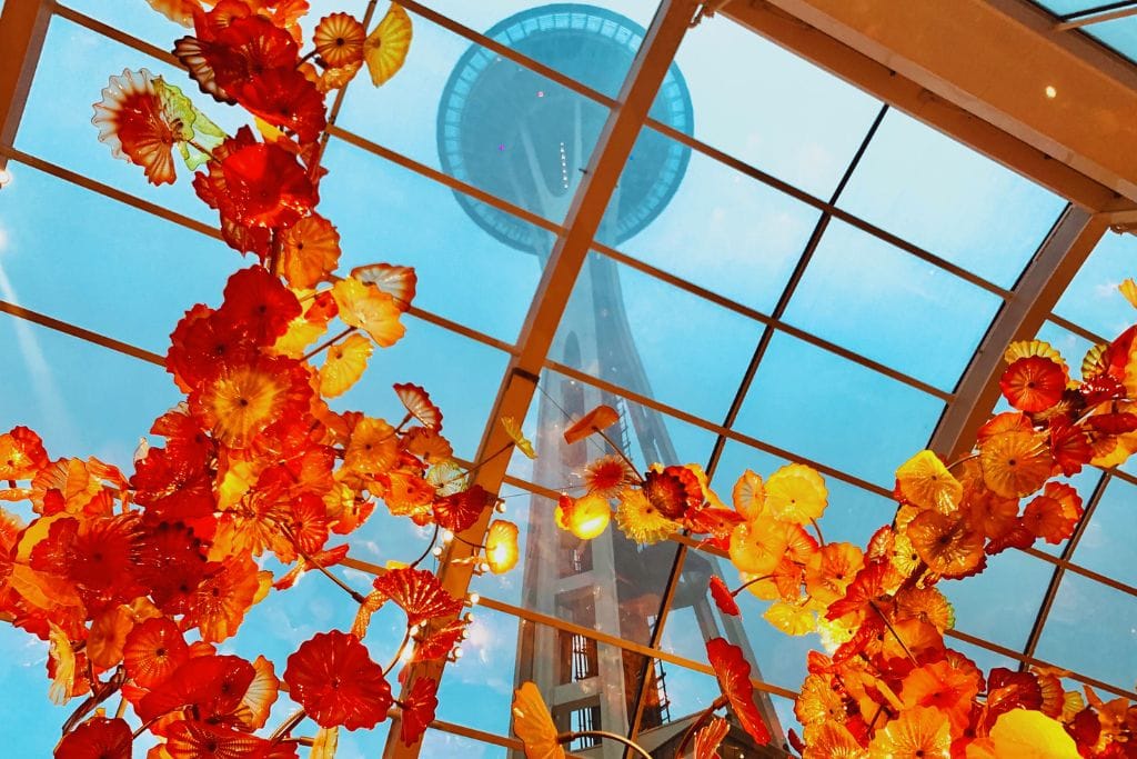 A picture of one of the art installations in the Chihuly Gardens and Glass exhibit. You can also see the Seattle Space Needle above. Tourist attractions in Seattle can be both really expensive or pretty affordable.