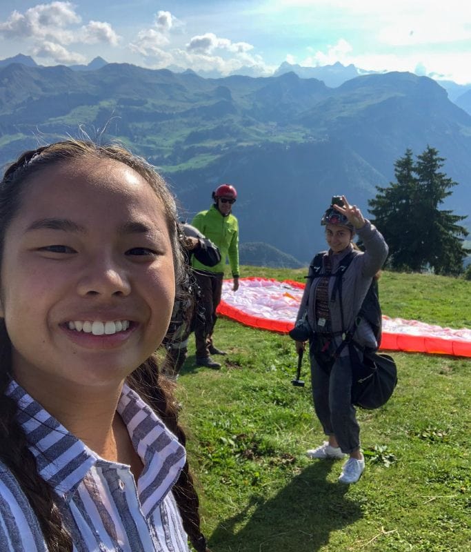 A picture of Kristin and her friend smiling before going paragliding. 