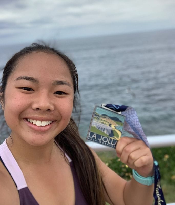 A selfie picture of Kristin with her medal post race at the La Jolla Half Marathon