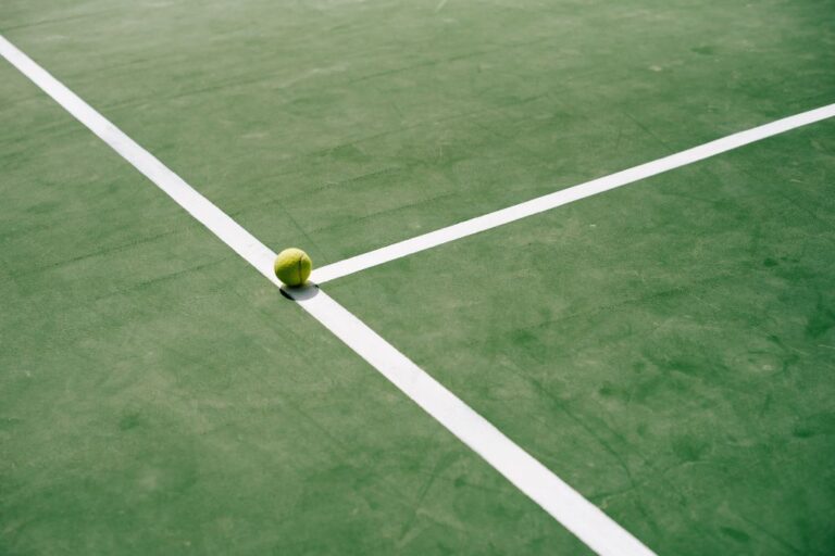 A picture of a tennis court with a tennis ball on the T.