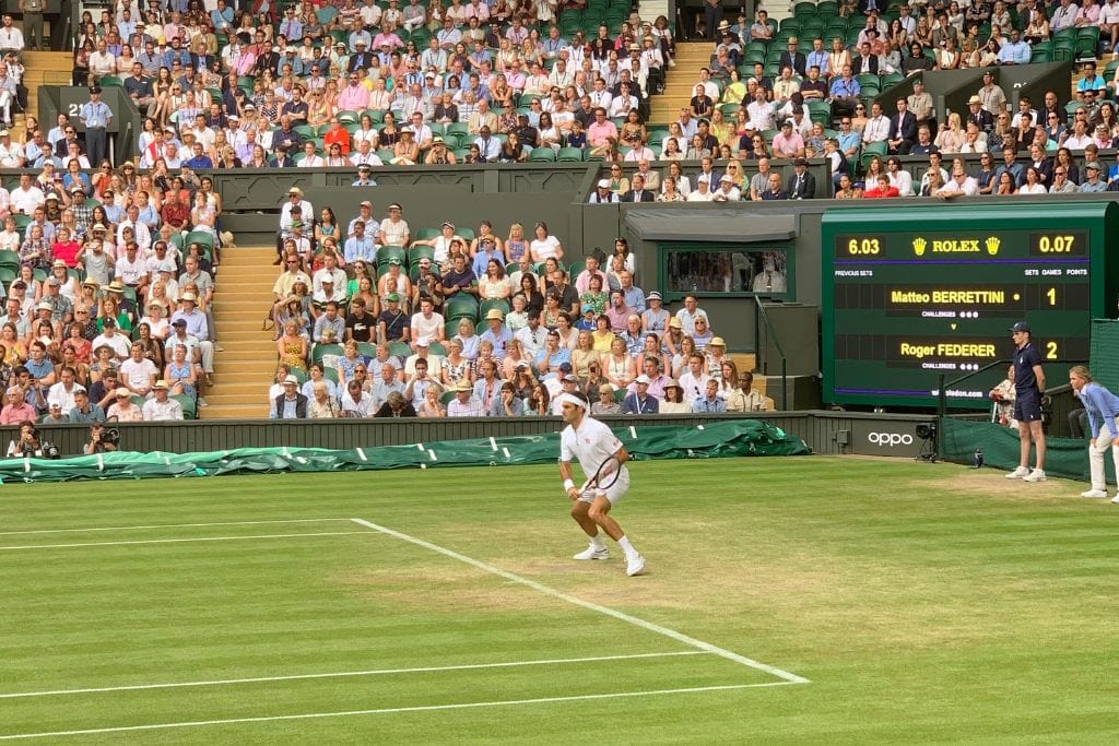 Roger Federer playing tennis on Centre Court at Wimbledon.